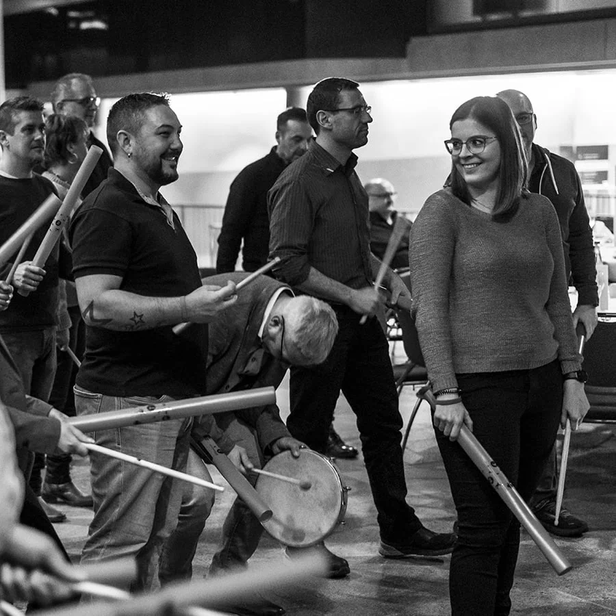 Gruppe von Musikern mit verschiedenen Instrumenten während eines Team-Events, einige spielen Flöten und andere Percussion.